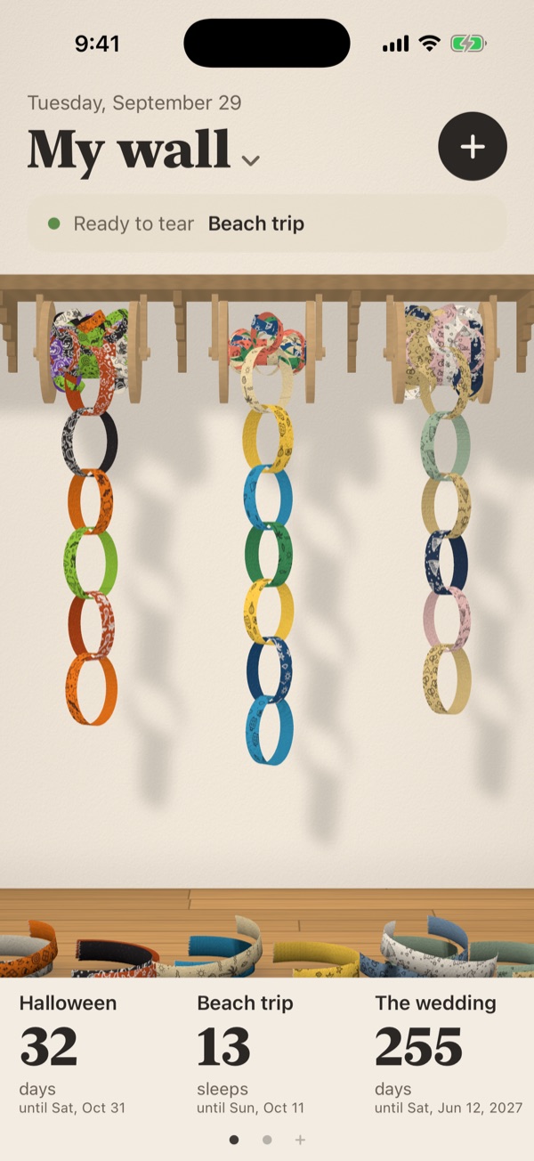 A cream wall with three paper chains: Halloween, Beach trip, and The wedding, with torn scraps on the floor